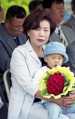 장미꽃다발을 들고있는 아이를 안고있는 아주머니사진(00002)