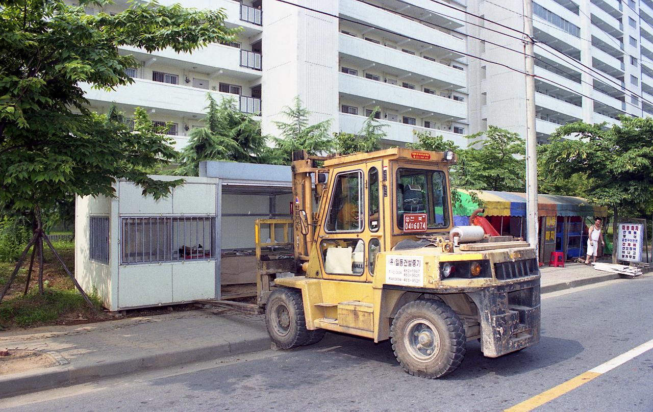 지게차로 컨테이너박스로 된 건물을 들어올리는 장면