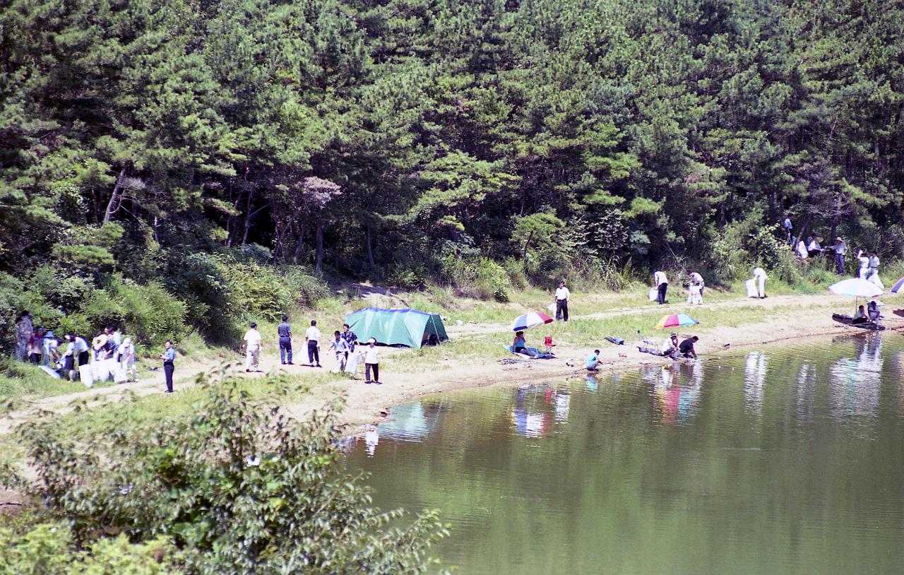 은파유원지에서 피서를 즐기고있는 사람들과 청소하고있는 사람들