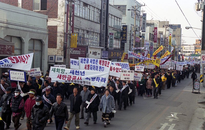현수막을 들고 행진하는 새만금 유치 시민권리 대회 참가자들2