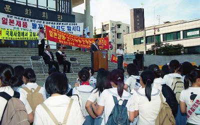 시민문화회관앞에서 현수막을 들고 말씀하고 계신 관련인사와 서서 듣고 계신 사람들