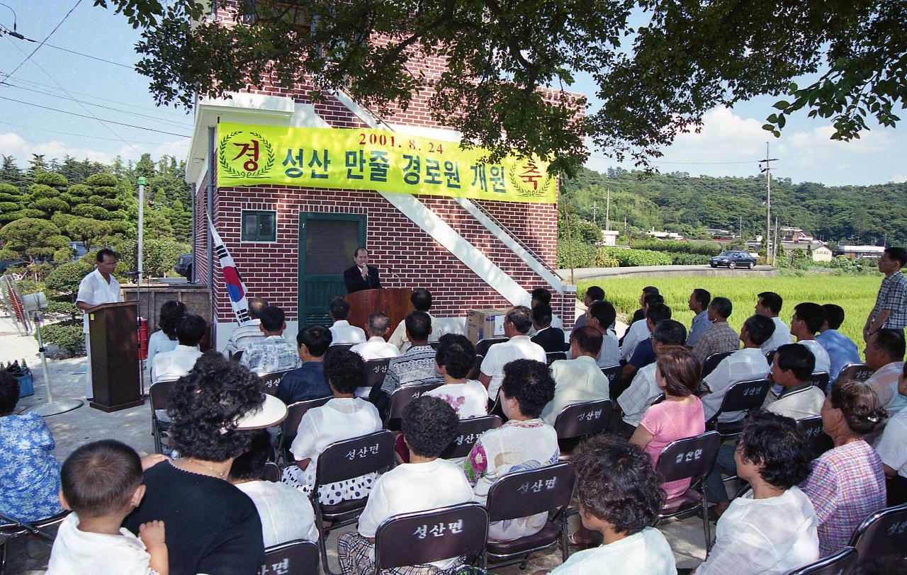 성산 만줄경노당 개원을 축하하며 무대 위에서 말씀하고 계신 시장님과 자리에 앉아 듣고 있는 시민들