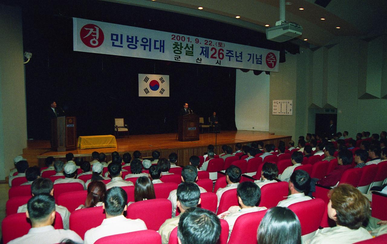 민방위대 창설 기념식에서 무대 위에서 말씀하고 계신 시장님과 자리에 앉아 듣고 계신 사람들