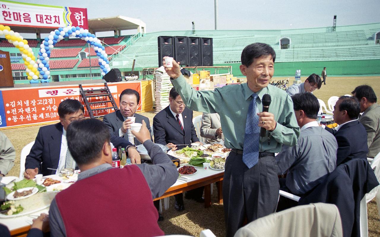 자리에서 일어나 잔을 들고 마이크에 대고 말씀하고 계신 관련인사