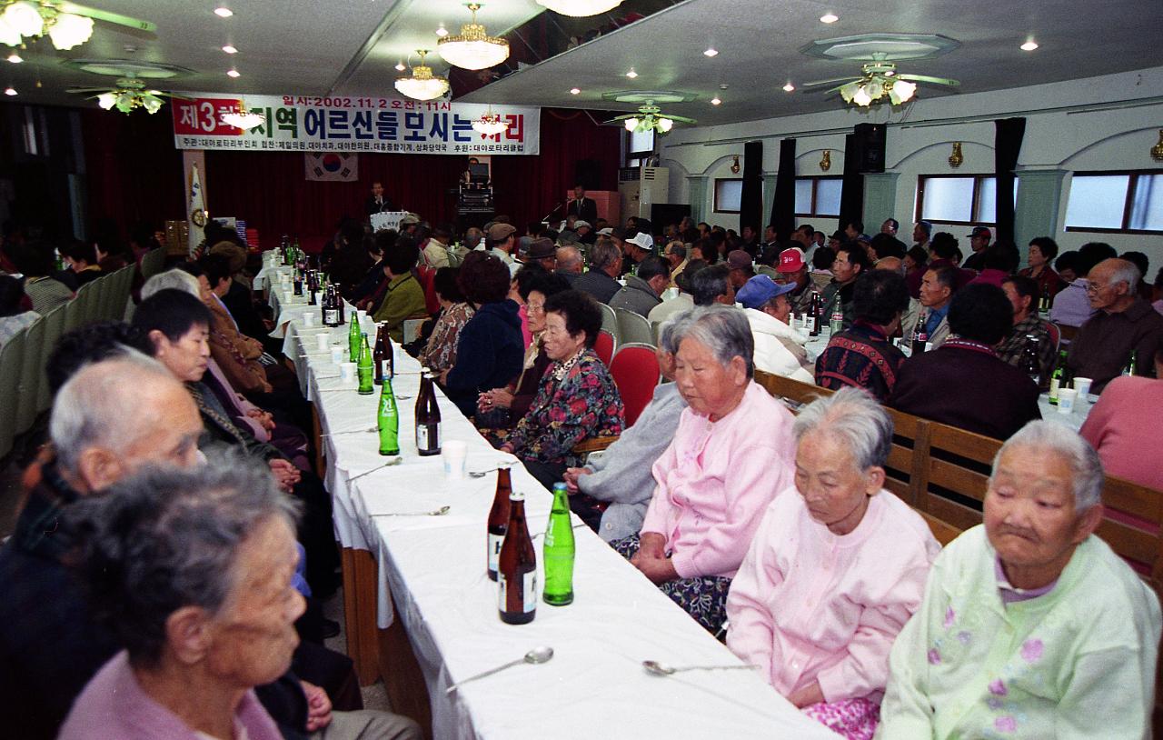 어르신 큰잔치에 오셔서 앞으로 나와 말씀하고 계신 시장님과 자리에 앉아 시장님의 말을 듣고 계신 어르신들3