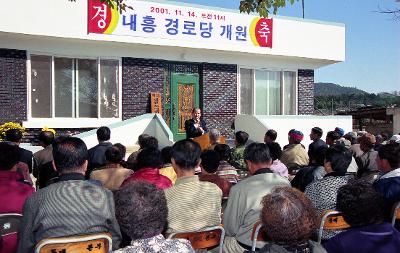 내흥경노당 개원식에서 앞으로 나와 말씀하고 계신 시장님과 자리에 앉아 듣고 계신 어르신들