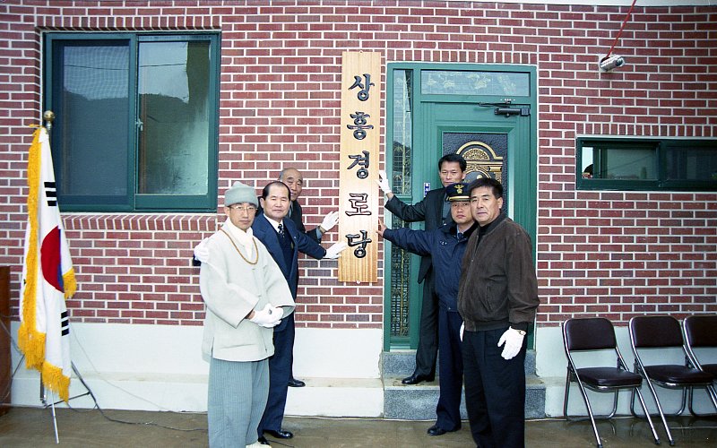 성산면 상흥경노당의 문패를 가리키며 개원을 기념하는 사진을 찍고 있는 시장님과 관계자들