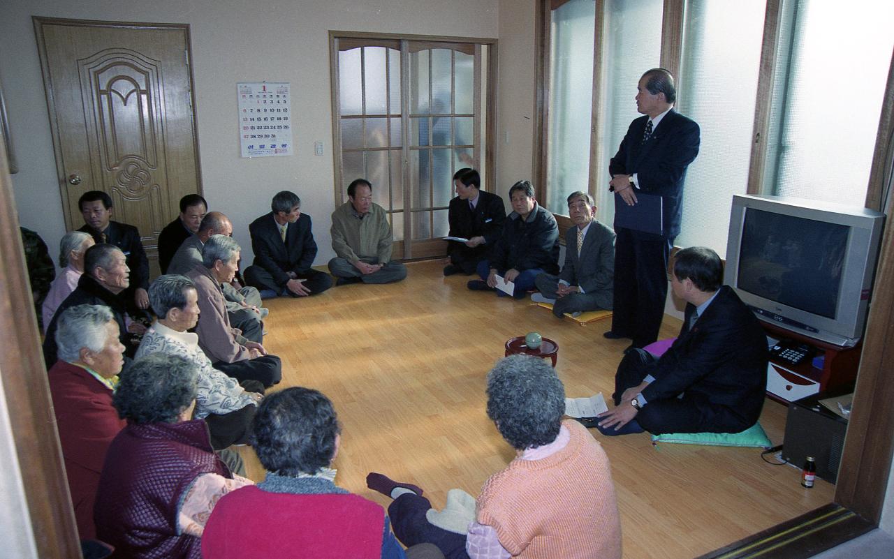 개정 우산 경노당에서 일어나 개원을 축하하는 말씀을 하고 계신 시장님과 앉아서 듣고 계신 어르신들