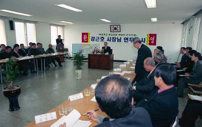 일어나서 말씀하고 계신 직원과 자리에 앉아 듣고 있는 시장님과 직원들