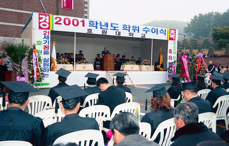 호원대학교 졸업식에서 앞에서 말씀하고 계신 시장님과 자리에 앉아 듣고 있는 졸업생들