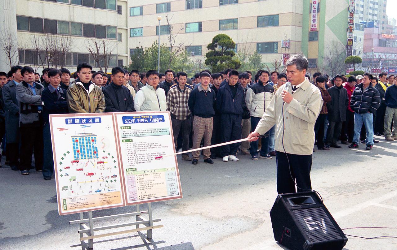 자료를 가리키며 도단위 민방위 훈련에 대해 설명하고 계신 관계자