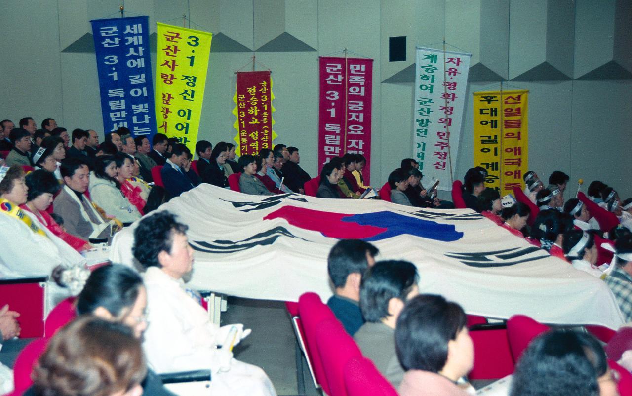 벽에 세워져 있는 많은 현수막들과 객석에 펼쳐져 있는 태극기와 함께 객석에 앉아 말씀을 듣고 계신 사람들1