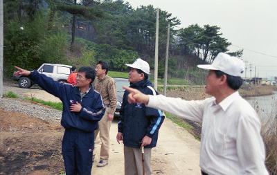 산불현장을 가리키며 말씀을 나누고 계신 마을사람들과 시장님