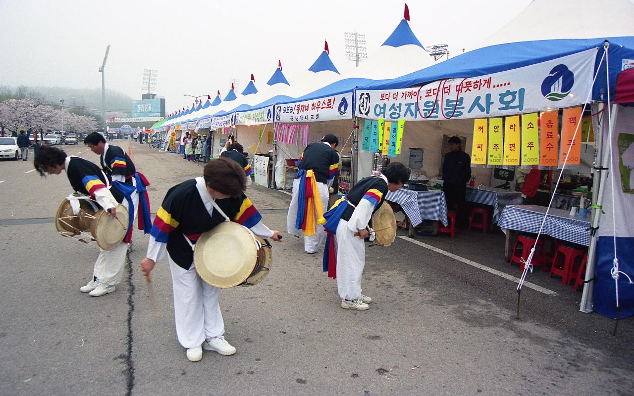 벚꽃축제 노점상 앞에서 인사를 하고 있는 사물놀이패