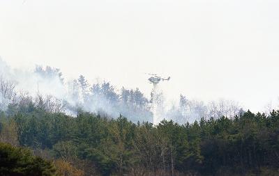 불이 붙은 곳에 물을 뿌리고 있는 헬리콥터1