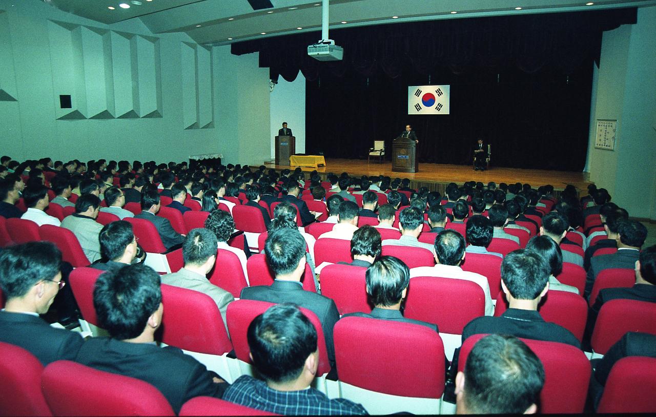 무대 위에서 말씀을 하고 계신 시장님과 자리에 앉아 듣고 있는 임원들