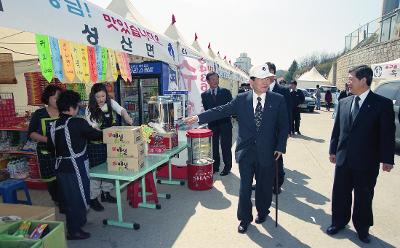 먹거리가 있는 천막아래를 손가락으로 가리키며 관련인사와 말씀을 나누고 계신 시장님