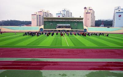 인조잔디구장에 서 있는 사람들