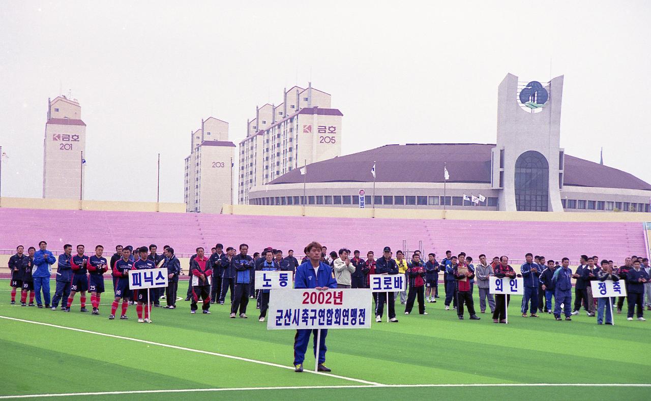 팻말을 들고 인조잔디구장에 서 있는 사람들