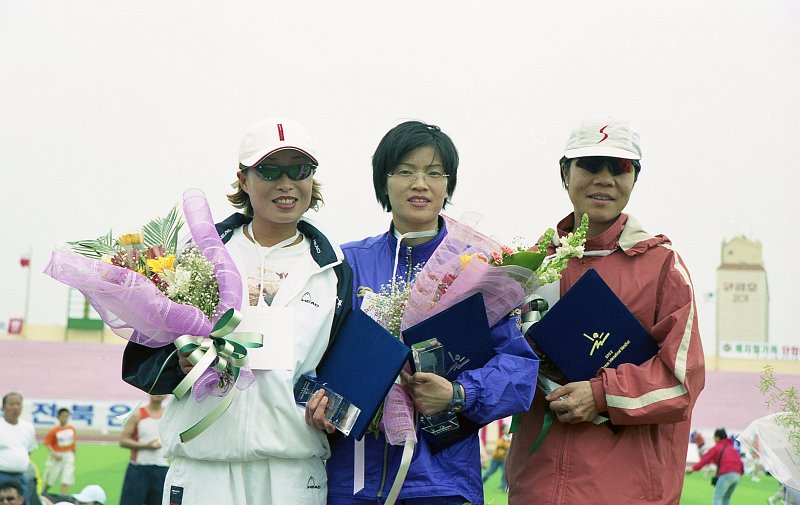 트로피와 상장과 꽃다발을 들고 사진을 찍고 있는 여성참가자들