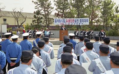 월드컵대비 교통안전 실천대회에서 앞에서 말씀을 하고 계신 시장님과 팻말을 들고 서서 말씀을 듣고 계신 경찰들