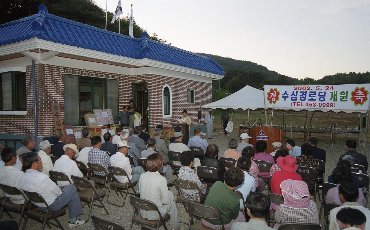 수심경노당 개원식에서 앞에서 사회를 보고 계신 진행자와 자리에 앉아 듣고 계신 어르신들