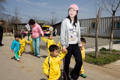 선생님의 손을 꼭 잡고 걸어가는 어린이들