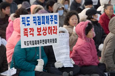 직도 직접피해주민 즉각 보상하라 라는 팻말을 들고 시위하는 피해시민들