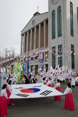 큰 태극기를 펼쳐 들고 있는 여성 참가자들과 그 뒤에서 깃발을 들고 하얀 옷을 입고있는 참가자들의 모습4