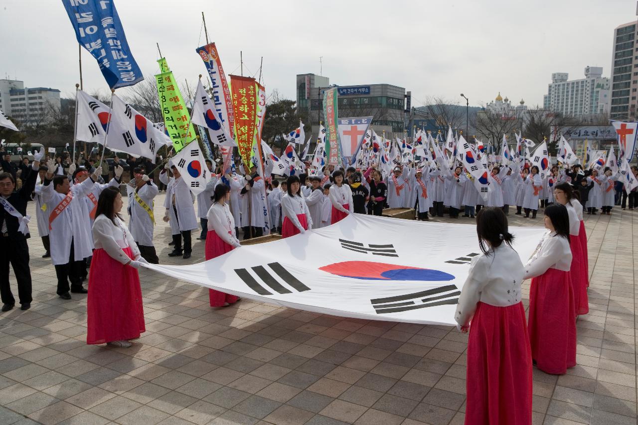 큰 태극기를 펼쳐서 서있는 여성 참가자들과 둘러싸고 있는 태극기 깃발을 들은 참가자들의 모습2