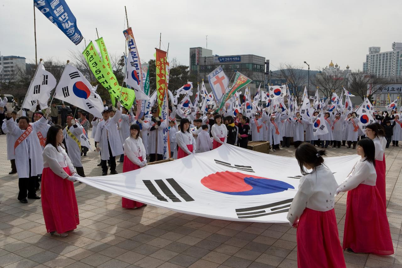 큰 태극기를 펼쳐서 서있는 여성 참가자들과 둘러싸고 있는 태극기 깃발을 들은 참가자들의 모습3