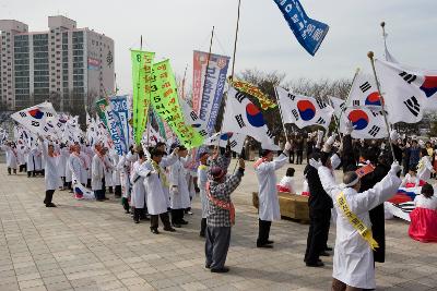 태극기 깃발을 들고 만세를 외치는 3.1절 기념식 참가자들