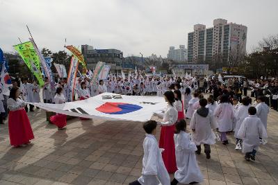 큰 태극기를 펼쳐서 서있는 여성 참가자들과 둘러싸고 있는 태극기 깃발을 들은 참가자들의 모습1