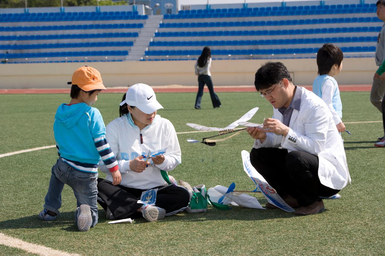 아이와 함께 모형항공기를 만들고있는 부모님의 모습