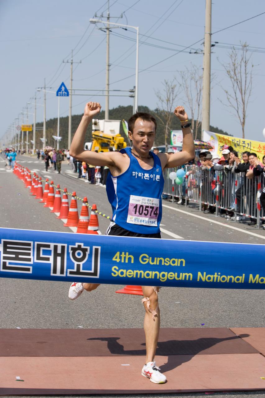 양손을 들고 결승선을 통과하는 마라톤대회 참가자