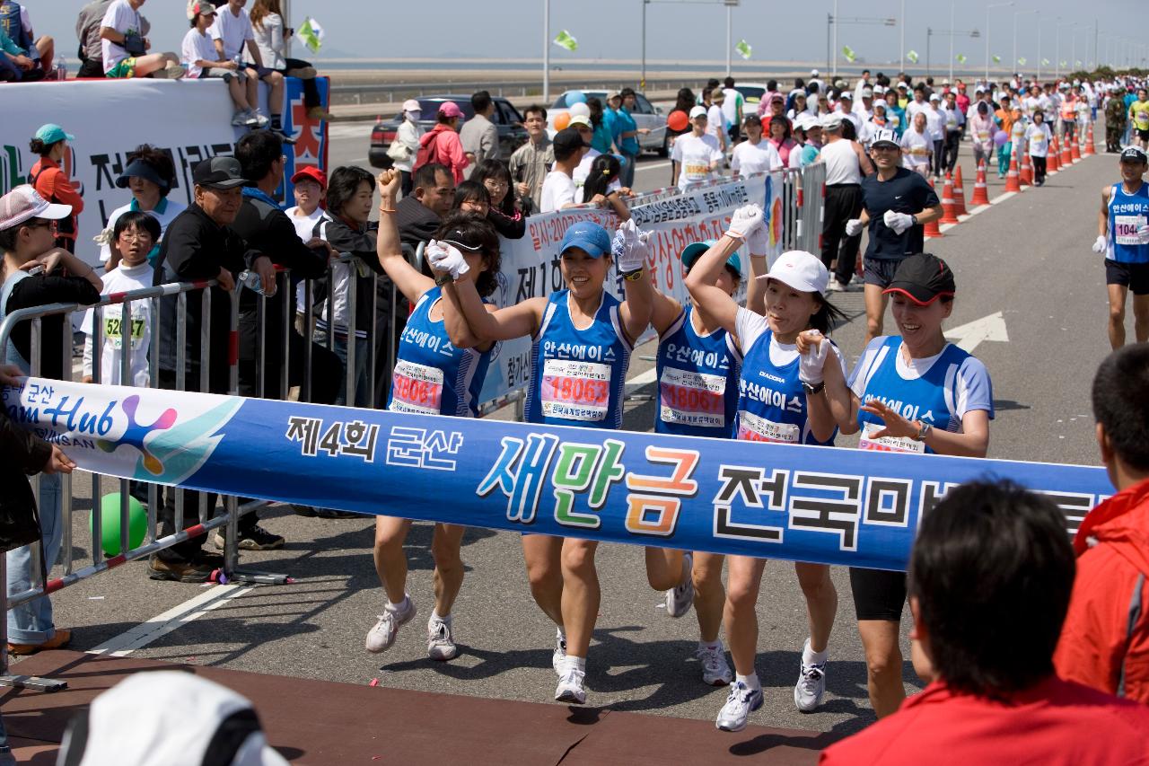 단체로 결승선을 통과하는 파란색옷을 입은 단체 마라톤대회 참가자들