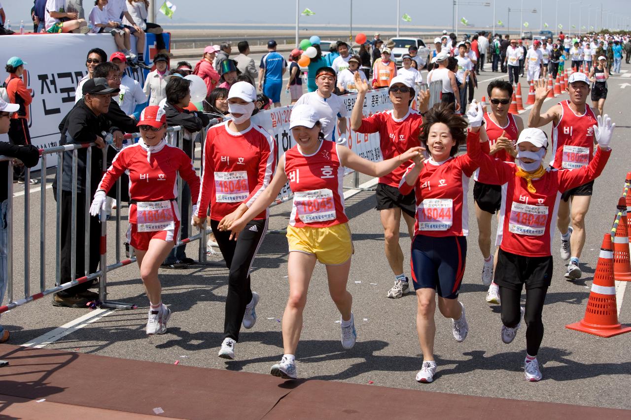 빨간색 단체복을 입고 달리는 마라톤 대회 단체참가자들