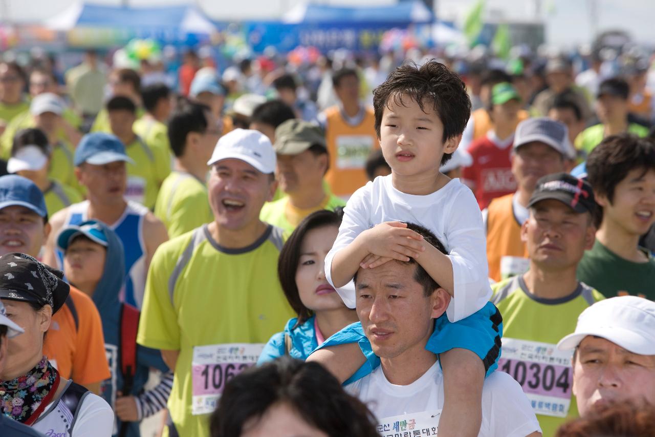 군산 새만금 마라톤 대회에 참가한 참가자들 사이에 목마를 타고 있는 아이의 모습