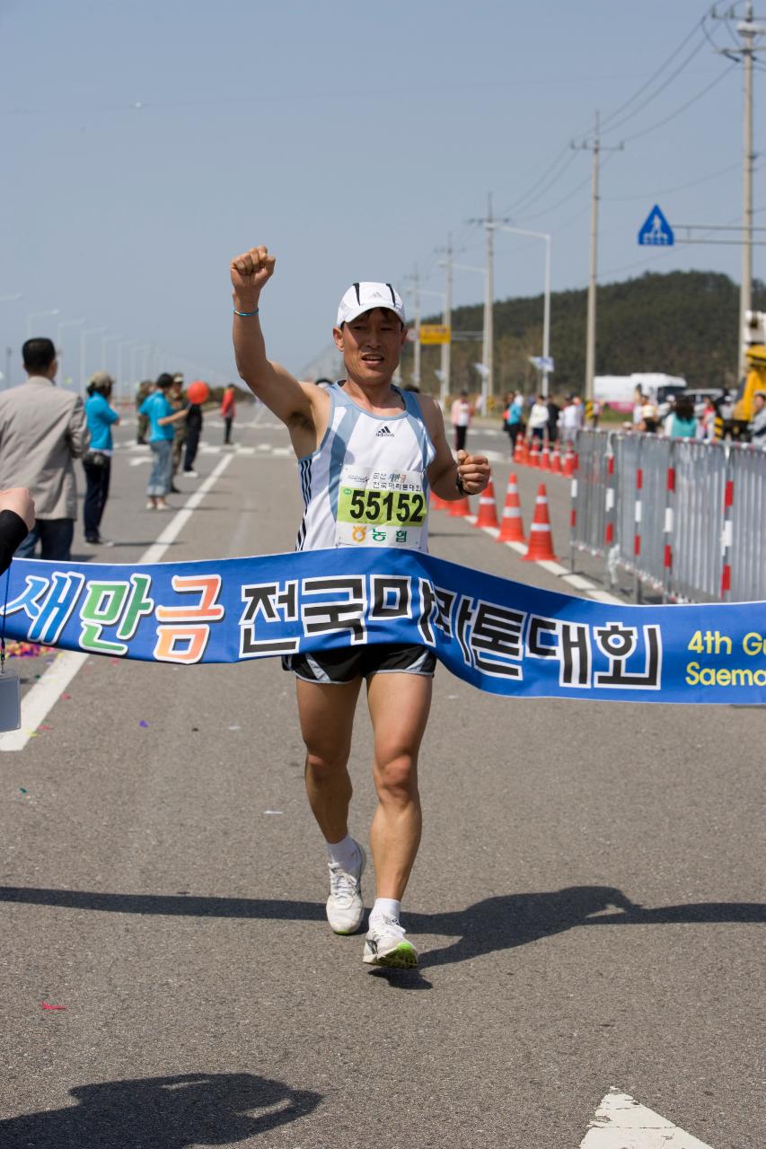 한손을 들고 결승선을 통과하는 참가자