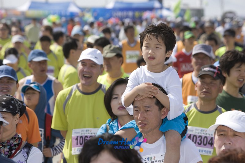 군산 새만금 마라톤 대회에 참가한 참가자들 사이에 목마를 타고 있는 아이의 모습
