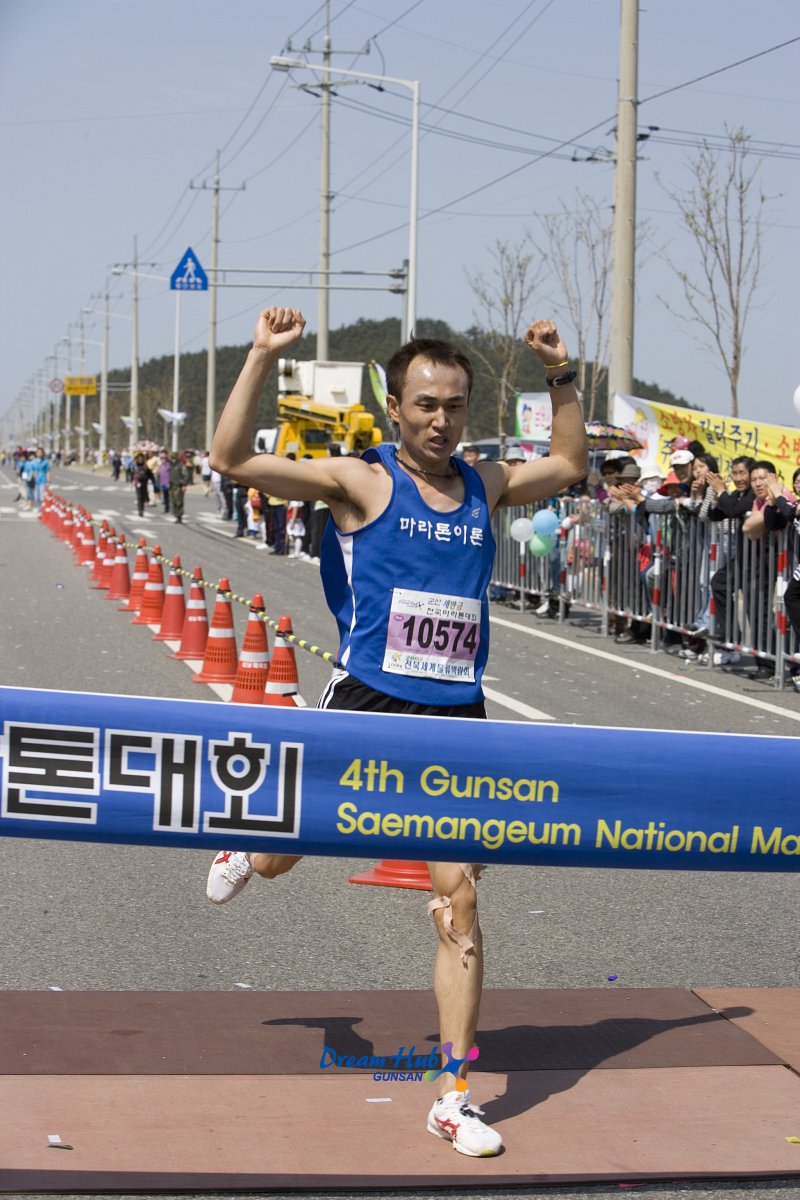 양손을 들고 결승선을 통과하는 마라톤대회 참가자