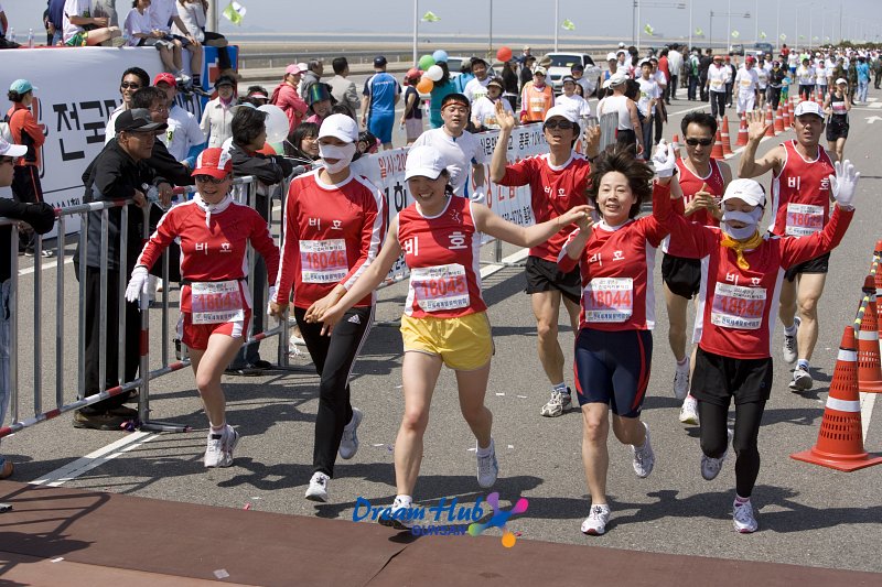 빨간색 단체복을 입고 달리는 마라톤 대회 단체참가자들