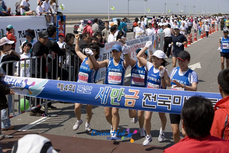 단체로 결승선을 통과하는 파란색옷을 입은 단체 마라톤대회 참가자들