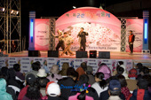 제11회 군산 벚꽃 예술제에 참가해서 무대위에서 노래하시는 시민과 뒤에서 춤추시는 시민의 모습1사진(00007)