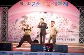 제11회 군산 벚꽃 예술제에 참가해서 무대위에서 노래하시는 시민과 뒤에서 춤추시는 시민의 모습2사진(00008)