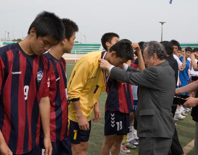 축구선수들에게 메달을 걸어주고 있는 관련인사