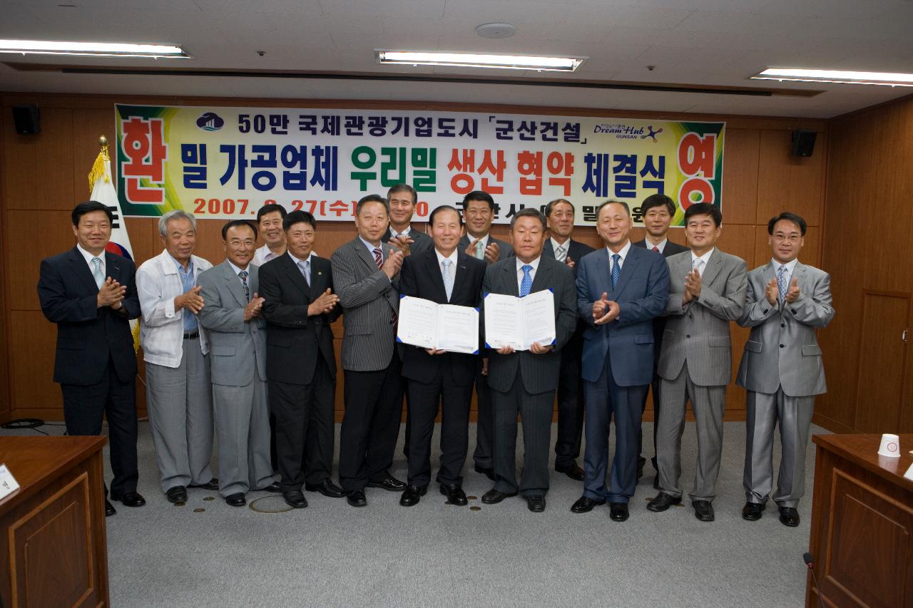 체결문을 들고 기념사진 찍으시는 기업대표님과 문동신 시장님 양옆으로 서서 박수치는 임원들