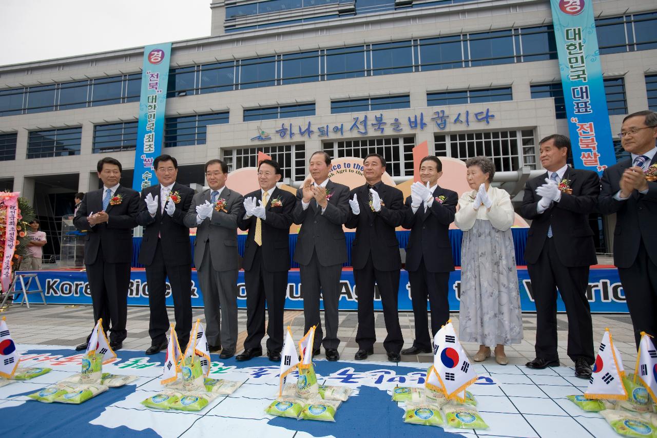 바닥에 열려있는 쌀포대에 태극기 깃발을 꽂고 박수치시는 김완주 도지사님과 문동신 시장님과 관련인사들