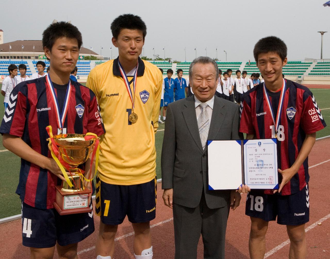 트로피와 상장을 들고 기념사진을 찍고 있는 관련인사와 축구대표