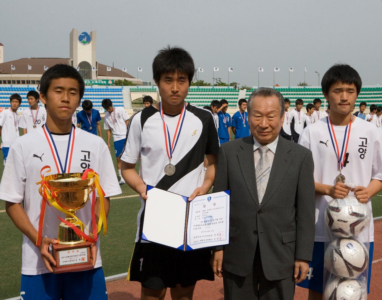 트로피와 상장을 들고 기념사진을 찍고 있는 축구대표들과 관련인사